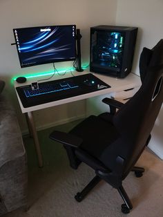 a computer desk with two monitors and a gaming keyboard on it, sitting next to a chair