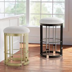 two stools sitting next to each other on top of a hard wood floor in front of a window