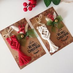 two christmas cards with red and white decorations on them next to holly leaves, berries and bells