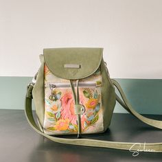 a green purse sitting on top of a table next to a white and blue wall