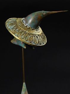 a metal bird with a hat on it's head