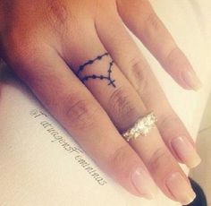 a woman's hand with a small tattoo on it