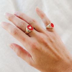 The IVY ENAMEL HEART SIGNET RING features cherry red enamel with a dainty accent heart in the center. Ring measures 14mm in height and is available in ring size 7. Please allow 5-7 business days for this style to ship. Red Enamel Jewelry For Anniversary, Personalized Enamel Ring As Gift, Personalized Enamel Ring For Gift, Personalized Enamel Rings As Gifts, Personalized Enamel Rings For Gifts, Gold Enamel Heart Ring For Anniversary, Red 14k Gold Heart Ring For Promise, Red 14k Gold Heart Promise Ring, 14k Gold Red Heart Ring For Promise