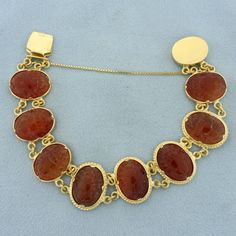 In 18k yellow gold. Contains 8 intricately carved carnelian beetles set in 18k yellow gold frames linked together. 6 3/4 inches long, 19mm wide. Slide clasp with safety chain. 28.9g.   Inventory 17709 Formal Cameo Jewelry In Carnelian, Formal Gold Carnelian Jewelry, Formal Carnelian Cameo Jewelry, Formal Cameo Carnelian Jewelry, Victorian Carnelian Jewelry For Formal Occasions, Gold Carnelian Bracelet, Beetle Scarab, Scarab Bracelet, Gold Frames