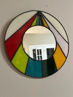 a colorful mirror hanging on the wall