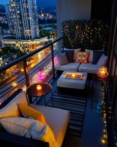 a balcony with couches, tables and candles on it