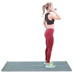 a woman in red leggings is talking on her cell phone while standing on a yoga mat