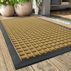 a large mat on the ground in front of some potted plants and two planters