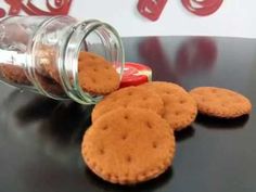 some cookies are sitting on a table next to a jar