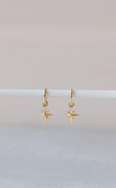 Indulge in the celestial elegance of our Northstar Earrings. Crafted from luxurious 14K gold, these earrings feature a delicate northstar charm that adds a touch of sophistication to any outfit. Elevate your style and shine like a star with these exquisite earrings. Celestial Yellow Gold Earrings Tarnish Resistant, Elegant Hoop Earrings With Star Charm, Celestial 14k Yellow Gold Earrings, Celestial Single Earring In Yellow Gold, Celestial Yellow Gold Single Earring, 14k Yellow Gold Celestial Earrings, 14k Gold Celestial Yellow Gold Earrings, North Star Earrings, Elegant Gold Hoop Earrings With Star Charm