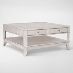 a white coffee table with two drawers on each side and an open drawer underneath it