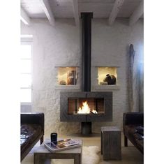 a living room filled with furniture and a fire place in the middle of it's wall