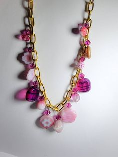 Designer Czech glass charms and fuschia Swarovski bicones dangle from a 10k gold plated 16in chain necklace. Multiple hues of pink. Luxury Czech Glass Necklaces, Pink Beaded Chain Necklace As Gift, Pink Glass Party Jewelry, Pink Glass Beaded Chain Jewelry, Pink Glass Jewelry With Beaded Chain, Handmade Pink Glass Jewelry, Pink Dangle Charm Necklaces, Pink Glass Jewelry For Jewelry Making, Pink Beaded Chain Jewelry For Gift