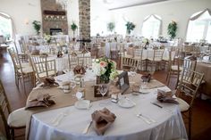 the tables are set for an event with white linens and brown napkins on them