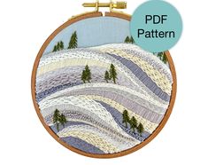 a cross stitch pattern with trees and mountains in the background