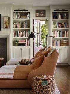 a living room filled with lots of furniture and bookshelves