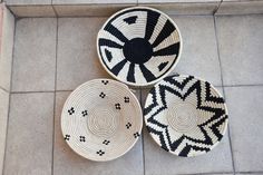 three black and white baskets sitting on top of a tile floor next to each other