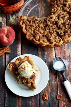 a slice of apple pie on a plate next to a fork and bowl of ice cream