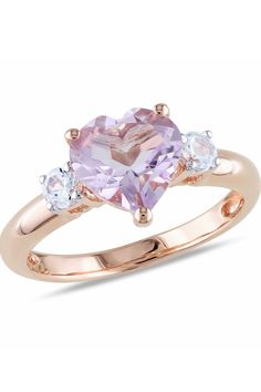 a pink heart shaped ring with three stones on the side and two diamonds in the middle