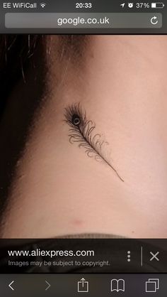 a woman's neck with a feather tattoo on it