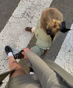 two people sitting on the ground with their legs crossed and one person holding something in her hand