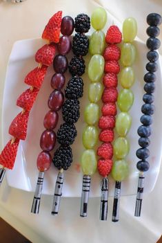 grapes, raspberries and other fruits are arranged on a plate