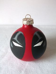 a red ornament with black and white designs on it's face is shown