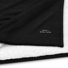 a black and white blanket with the words wish i were here printed on it's side