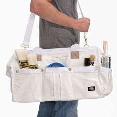 a man is holding a white bag with various items in it and he has his hand on the shoulder