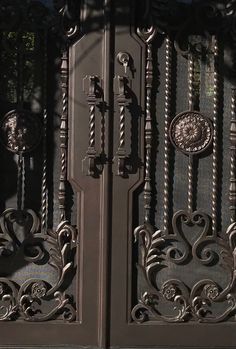 an ornate iron gate is shown in this image, it looks like it has been painted black