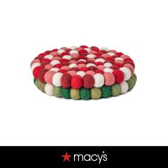 a red, white and green tray with pom - poms on the bottom