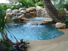 an outdoor pool with waterfall and palm trees