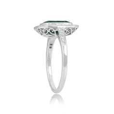 This ring features an emerald-cut Zambian emerald weighing 2.25 carats. The center stone is bezel-set and surrounded by a halo of baguette-cut diamonds weighing 0.75 carats. The shoulders are set with an additional five diamonds on each side weighing approximately 0.10 carats total. The mounting is decorated with an openwork under gallery and fine milgrain.
The measurements of this ring including the diamond halo are 13.35mm x 11.25mm. The measurements of the center stone are approximately 9.47m Zambian Emerald, Baguette Cut Diamond, Baguette Cut, Diamond Halo, Halo Diamond, Bezel Setting, Emerald Cut, Halo, Diamond Cuts