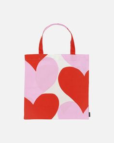 a pink and red bag with hearts printed on the front, sitting against a white background