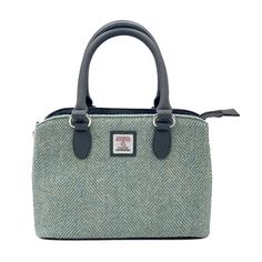 Harris Tweed Top Handle Bag Crafted from Genuine Harris Tweed with a vegan leather trim, this Top Handle Handbag is defined by its structured silhouette and generous space inside. The sturdy top handles are sized to fit comfortably in the crook of your arm, while a crossbody strap delivers easy and stylish hands-free wear. Inside this tweed handbag are two large compartments with a secure zip pocket on one side and 2 smaller open pockets on the other. The Harris Tweed bag is finished off with a Green Top Handle Bag With Leather Trim, Rectangular Tweed Bag For Fall, Rectangular Tweed Bags For Fall, Green Leather Trim Shoulder Bag For Shopping, Green Workwear Bag With Leather Handles, Green Shoulder Bag With Leather Trim For Shopping, Green Satchel For Fall, Green Bag With Leather Trim For Shopping, Green Bags With Leather Trim For Shopping