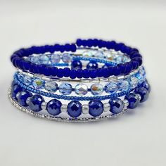 This Cobalt Wrap Bracelet Is Made On 6 Rows Of Silver Memory Wire With A Mixture Of Glass Beads, Bugle Beads, Czech Fire Polished Beads, And Sparkling Crystals In Gorgeous Blues. Hand Wrapped Blue Beaded Bangle Bracelet, Adjustable Blue Wrap Bracelet With Faceted Beads, Elegant Blue Stackable Crystal Bracelet, Adjustable Blue Stackable Wrap Bracelet, Adjustable Blue Stackable Stretch Bracelet, Blue Adjustable Stackable Stretch Bracelet, Blue Crystal Bracelet With Stackable Round Beads, Blue Stackable Wrap Bracelet As Gift, Blue Stackable Stretch Bracelet