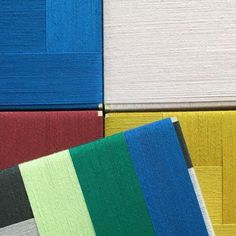 several different colors of fabric on top of each other in multiple rows, including blue, green, yellow, and white