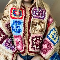 a woman wearing a crocheted sweater with colorful squares on the front and sides