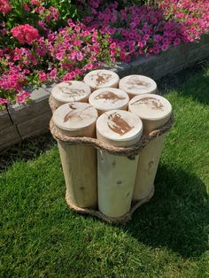 several logs stacked on top of each other in front of some pink and purple flowers