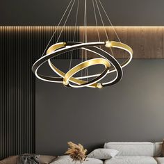 a modern chandelier hanging from the ceiling in a living room with white couches