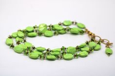 Take your style up a notch with this dramatic Lime Statement necklace. Three luscious strands of yellow, lime, and turquoise beads are combined with sparkling Swarovski© Crystal. The green glass swirl and copper seed beads to create a look that's sure to turn heads. The gold-colored chain is 16 to 19 inches in length, weighs 2 oz - making it perfect for any outfit. With its beautiful colors and eye-catching design, the Lime Statement necklace is sure to become one of your favorite accessories. Green Multi-strand Bracelet With Colorful Beads, Green Beaded Chain Jewelry, Green Multi-strand Costume Jewelry, Green Beaded Chain Bracelet For Jewelry Making, Green Oval Polished Beads Jewelry, Green Beaded Chain Bracelets For Jewelry Making, Elegant Lime Green Beaded Jewelry, Green Multi-strand Beads For Gifts, Green Beaded Necklace With Colorful Oval Beads