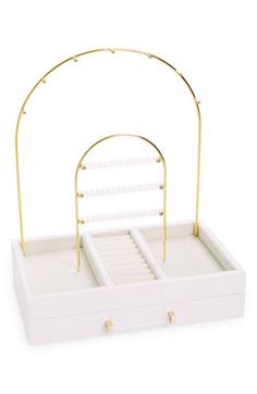 a white jewelry box with gold accents