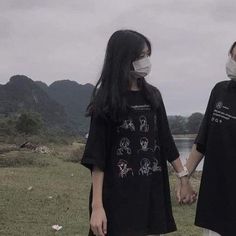 two people holding hands and wearing face masks