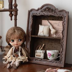 a doll sitting on a table next to a shelf