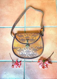 TOOLED LEATHER VINTAGE SHOULDER BAG 👜 Material - Genuine Thick Tan Leather. Hand tooled floral design.  Condition- Lightly worn vintage item. Lots of life left. Closure- Heavy duty turn lock clasp Medium Length adjustable strap  Fantastic festival bag!  Please enquire if you have any questions we are happy to help!  Happy shopping Xx KENAIV xX Handmade Vintage Satchel, Vintage Hand Tooled Tote Satchel, Vintage Style Hand Tooled Tote Satchel, Vintage Hand-tooled Tote Satchel, Vintage Handmade Shoulder Bag For Travel, Vintage Hand-tooled Crossbody Shoulder Bag, Vintage Brown Soft Leather Bag, Retro Hand-tooled Bags, Vintage Handmade Pouch Bag