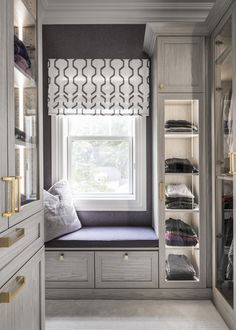 a window seat in the corner of a walk - in closet next to a window