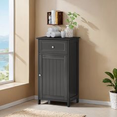 a bathroom with a potted plant on the floor and a cabinet next to it