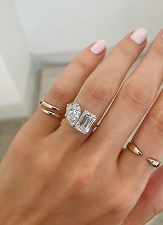 a woman's hand with three different rings on her fingers and one has an engagement ring