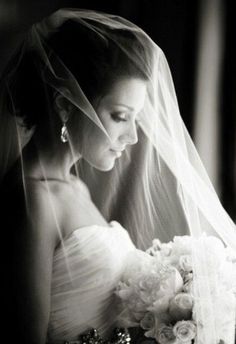 black and white photograph of a bride in her wedding dress with veil over her head