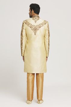 Gold sherwani with all-over zardozi and stone hand embroidery. Comes with gold pant. - Aza Fashions Semi-stitched Gold Kurta With Naqshi, Gold Sherwani With Intricate Embroidery In Raw Silk, Gold Sherwani With Resham Embroidery And Kundan, Traditional Gold Raw Silk Wear With Naqshi, Gold Traditional Wear With Naqshi Drape, Gold Churidar With Intricate Embroidery For Reception, Traditional Gold Unstitched Suit With Naqshi Detailing, Gold Raw Silk Sherwani With Zari Work, Traditional Gold Unstitched Suit With Naqshi